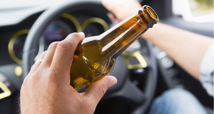 Man drinking beer while driving