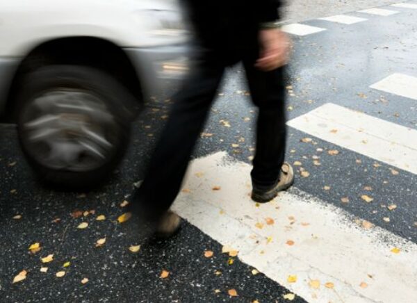 Man on pedestrian crossing in autumn in danger of being hit by car MAIN 1