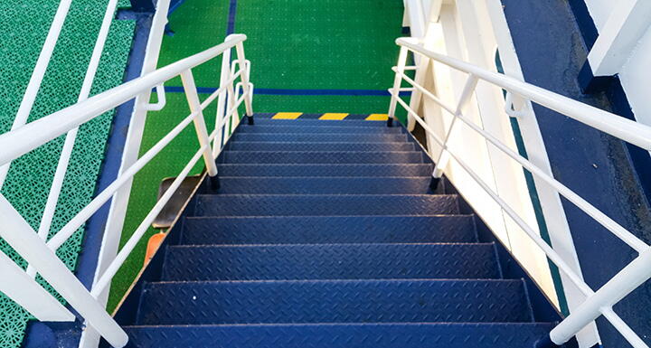 Blue staircase with white railing and green landing