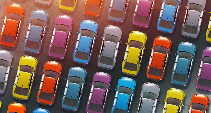 Aerial view of cars of various colors parked together in a parking lot