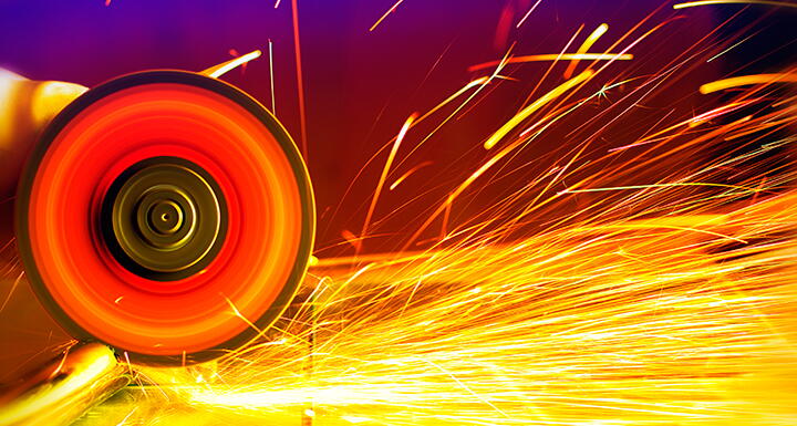 A metal circular saw going through sheet metal with sparks flying